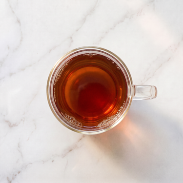 Rukeri Rwandan Black Tea brewed infusion in a glass cup