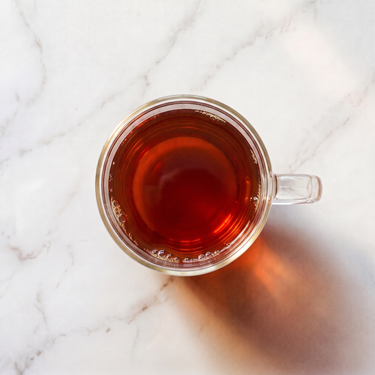 Tropical Paradise Rooibos Tea brewed infusion in a glass cup